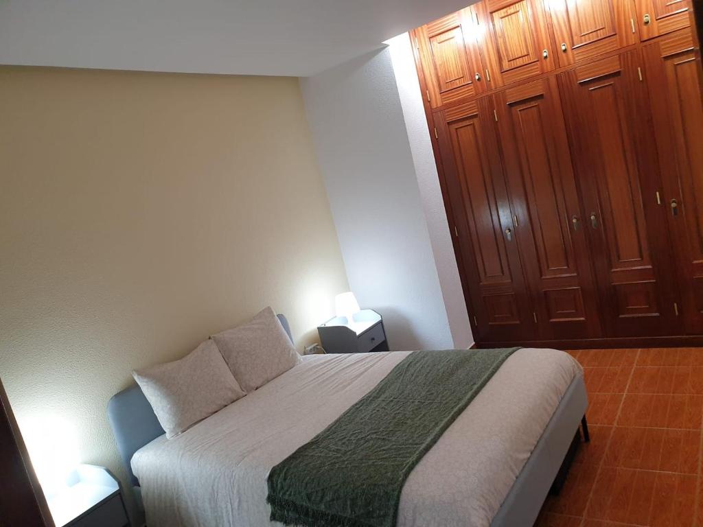 a bedroom with a bed and two wooden cabinets at Cantinho dos Montes in Vila Real