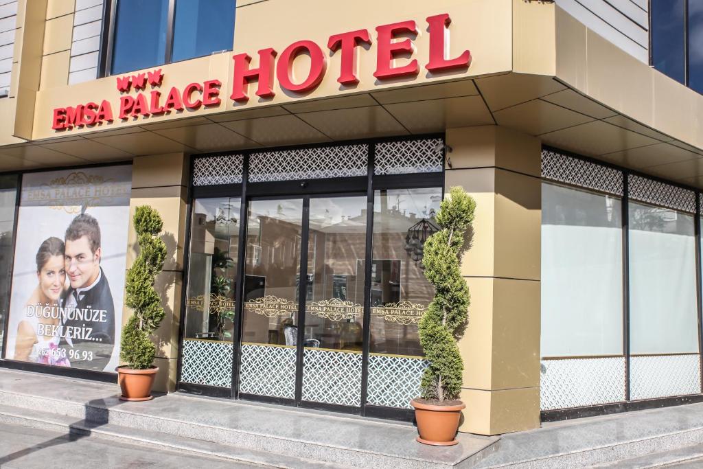 a large hotel with potted plants in front of it at Emsa Palace Hotel in Darıca