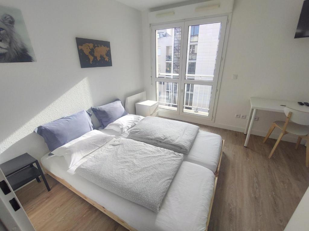 Schlafzimmer mit einem Bett, einem Schreibtisch und einem Fenster in der Unterkunft 10 mins walk to metro,La Défense, renovated in Courbevoie