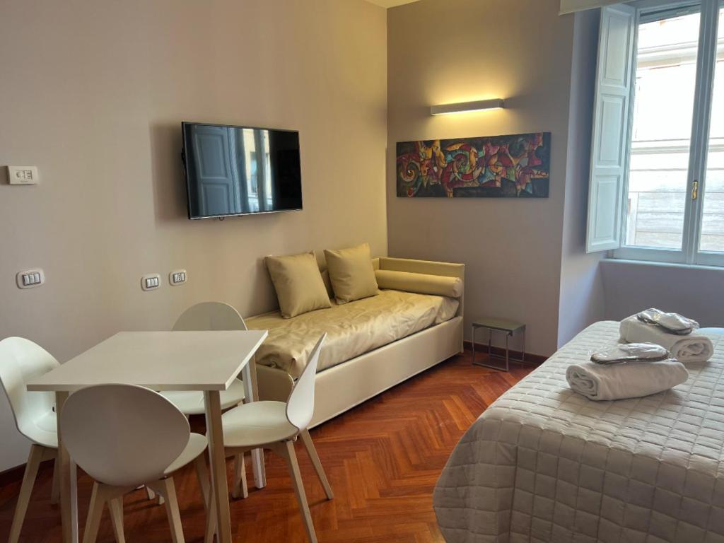sala de estar con sofá, mesa y TV en Dolce Vita Guest House en Roma