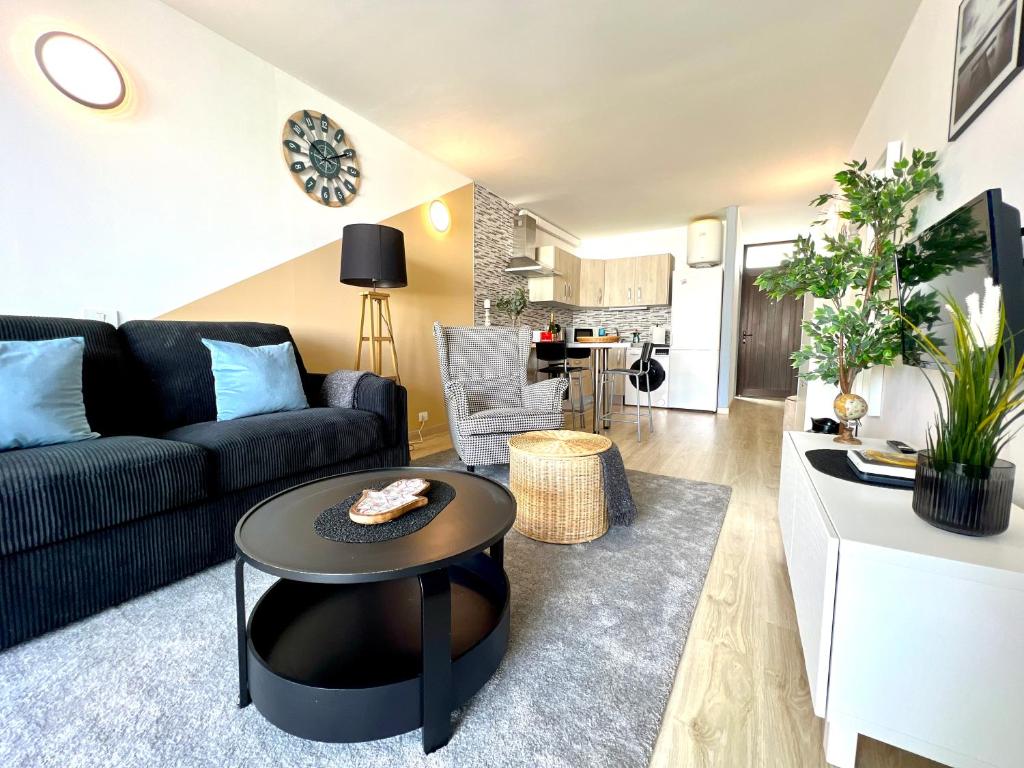 sala de estar con sofá negro y mesa en Stunning lovely flat with Pool and strong Wi-Fi, en Arona