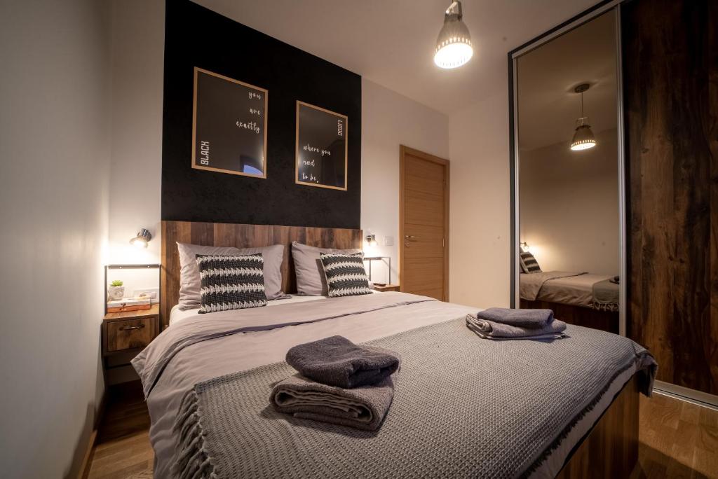 a bedroom with a large bed with towels on it at BlackWood Apartment Zlatibor in Zlatibor