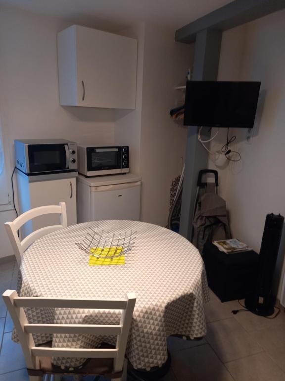une cuisine avec une table blanche et une serviette jaune dans l&#39;établissement SNTL, à Jonzac