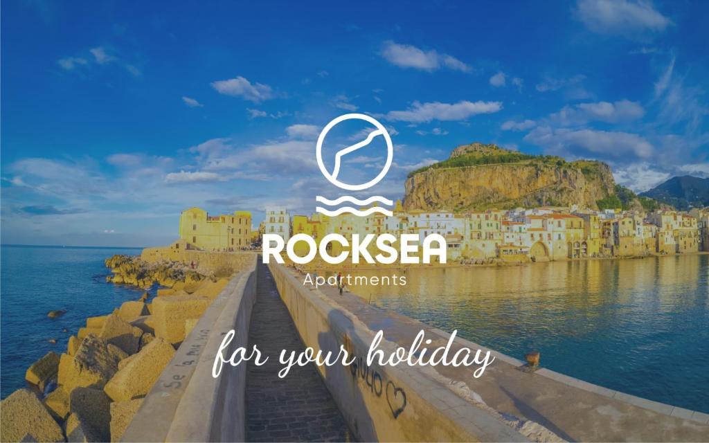 una vista di una città sull'acqua con le parole "rocksea for your holiday" di RockSea Apartments a Cefalù