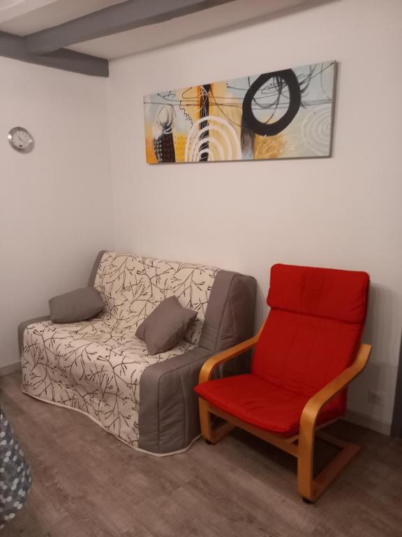 - un salon avec un canapé et un fauteuil rouge dans l&#39;établissement SNTL, à Jonzac