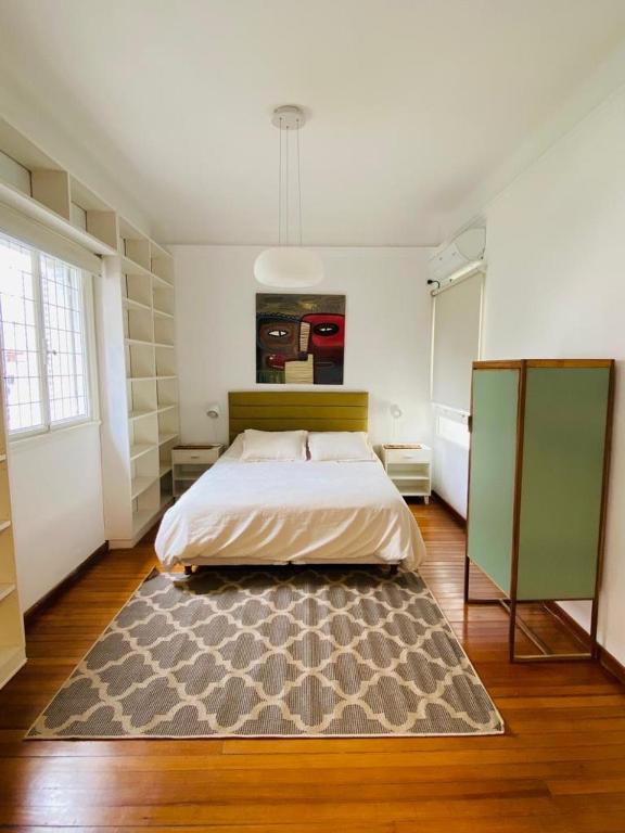 a bedroom with a bed and a rug on the floor at Depto de lujo frente al Botánico in Buenos Aires