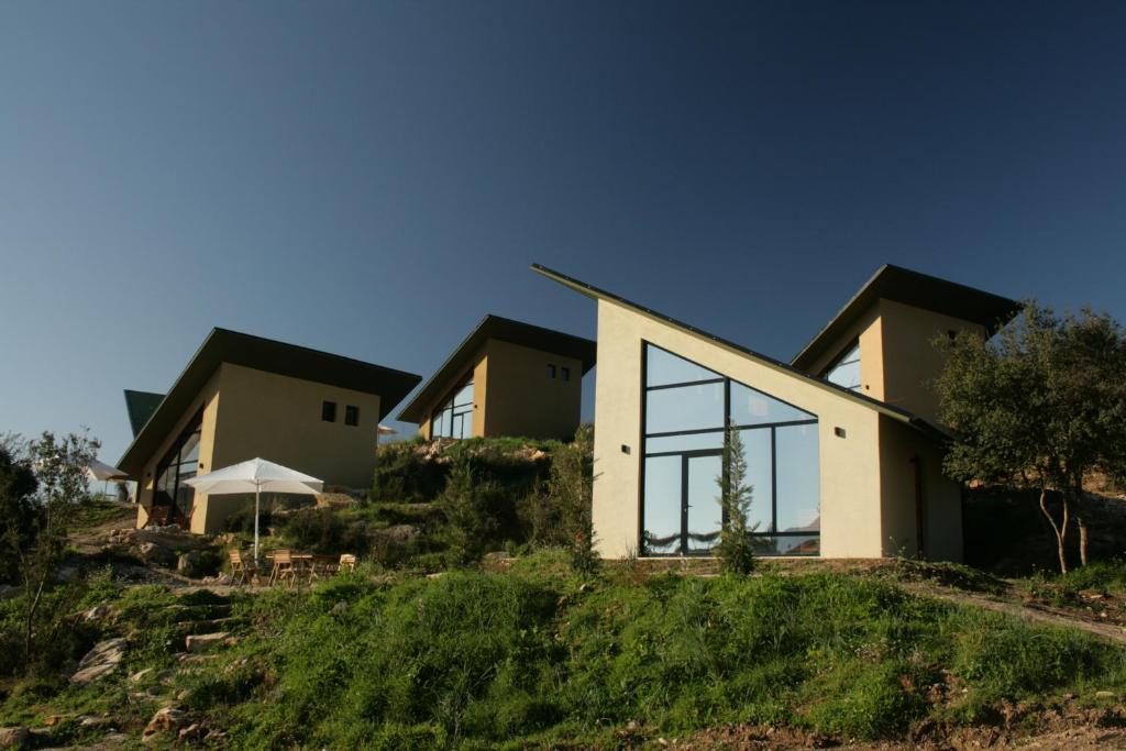 dom na wzgórzu z dużymi oknami w obiekcie Botë Farms Agriturismo w Sarandzie