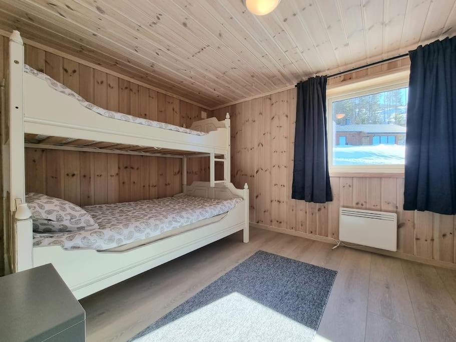 1 Schlafzimmer mit 2 Etagenbetten und einem Fenster in der Unterkunft Holiday cabin in beautiful surroundings in Vradal