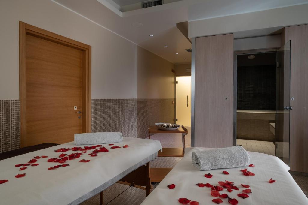 a bedroom with two beds with red roses on them at The Ziba Hotel & Spa in Peschiera del Garda