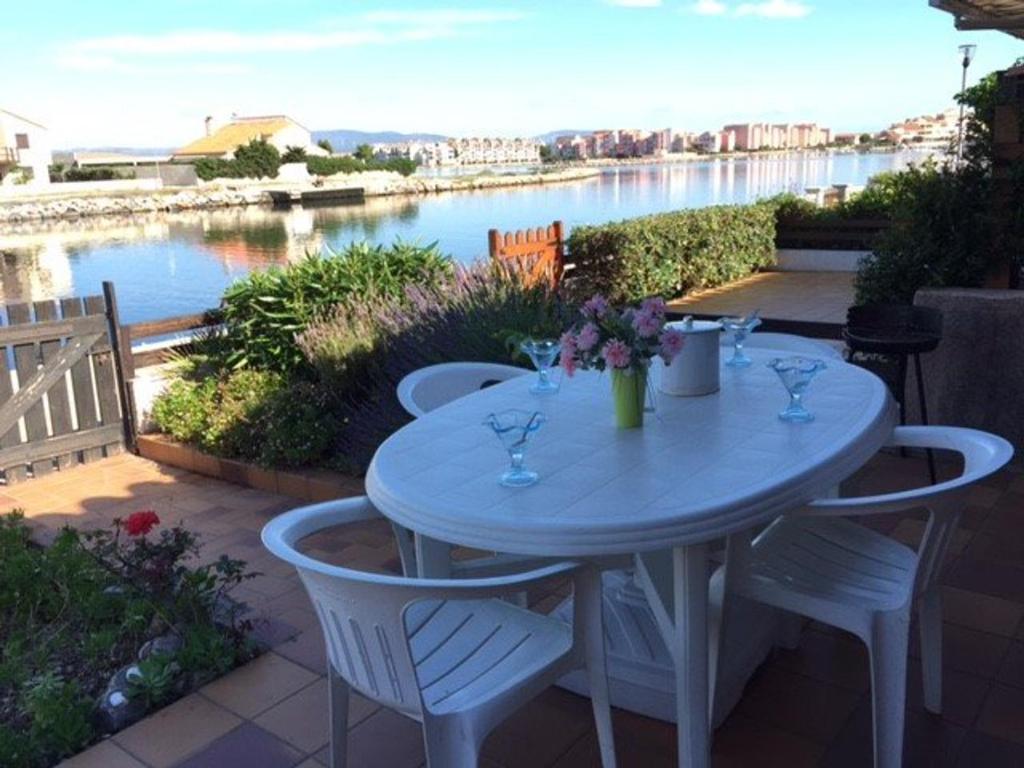 ル・バルカレスにあるVilla Port Barcarès, 3 pièces, 6 personnes - FR-1-81-256の川の景色を望む青いテーブルと椅子