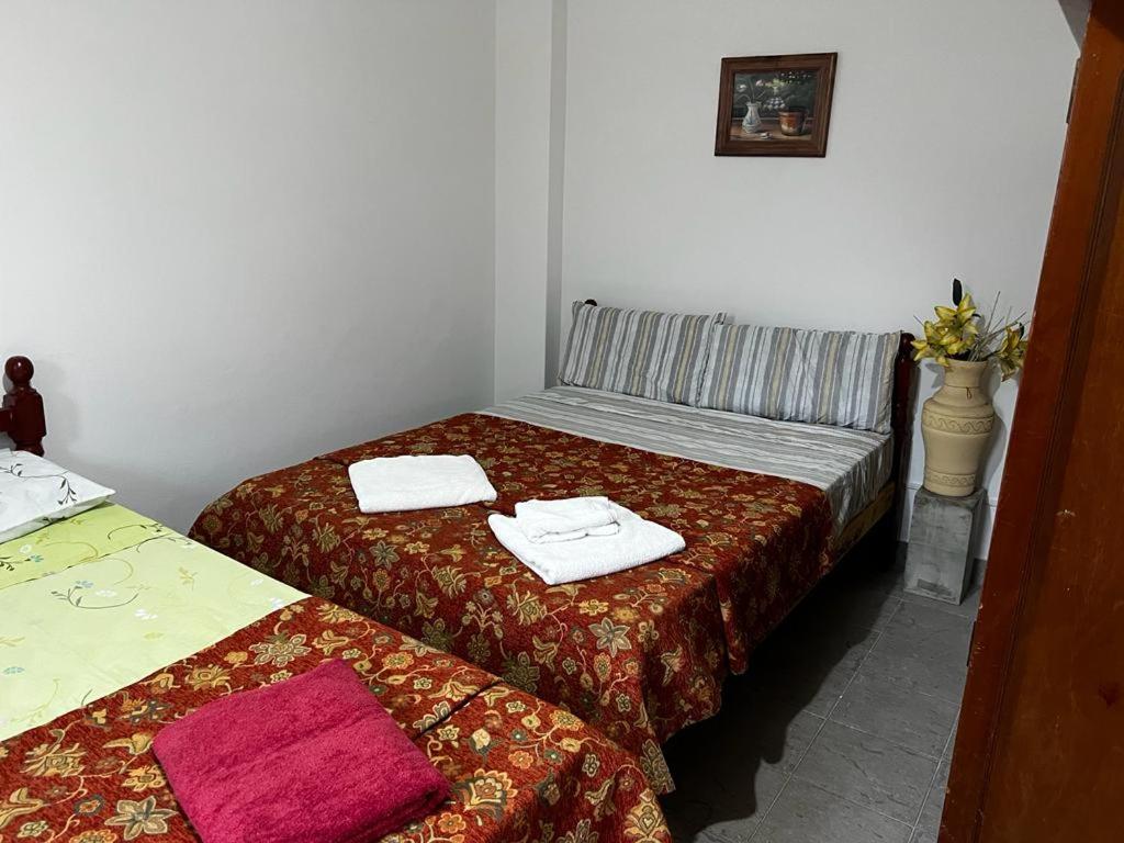 1 dormitorio con 2 camas y toallas. en Apart Hotel Comfort City en Salta