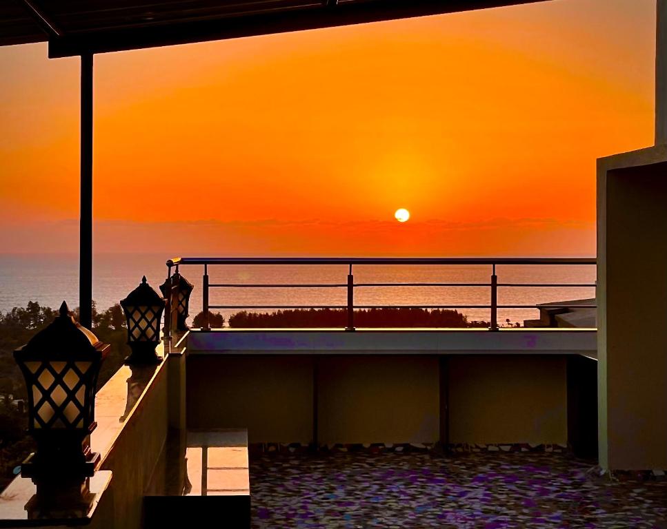 een zonsondergang over de oceaan vanuit een huis met twee lichten bij Fanta Sea Vacation Stay - 2 Bhk with private Terrace Flat in Ganpatipule