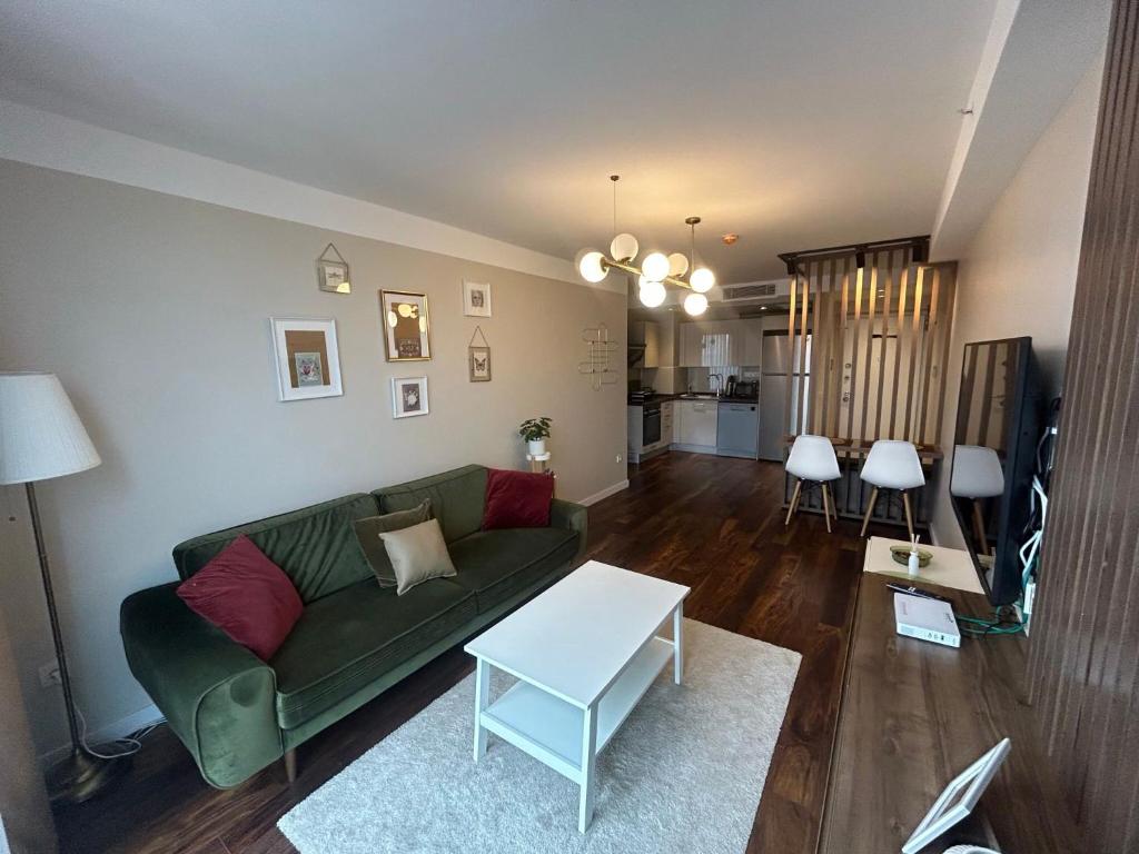 a living room with a green couch and a table at Arenya Home in Istanbul