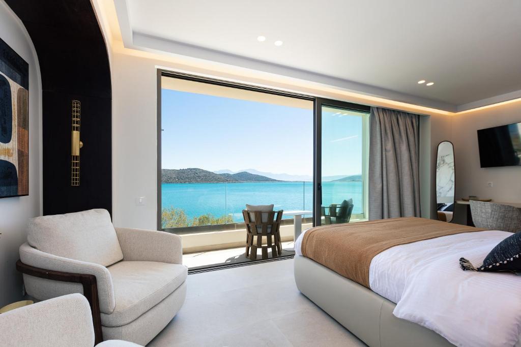 a bedroom with a bed and a view of the ocean at Naiades Boutique Hotel - Adults Only in Elounda