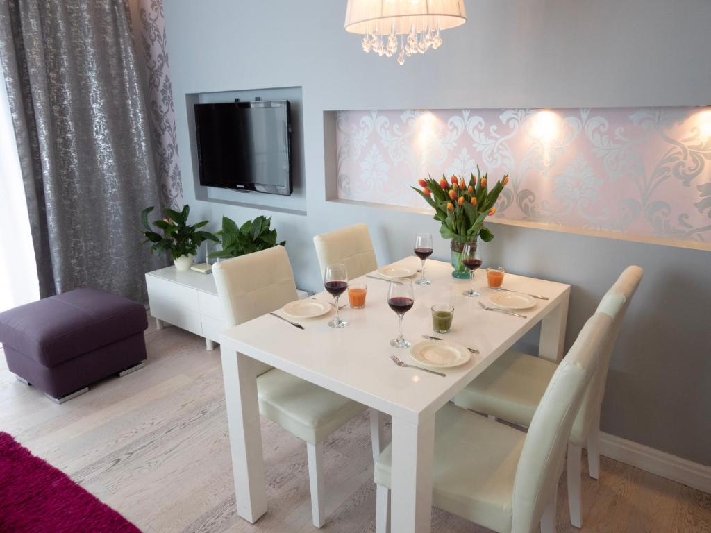 ein Esszimmer mit einem weißen Tisch und Stühlen in der Unterkunft Sunny Stay Apartment in Świnoujście