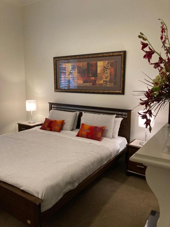 a bedroom with a large bed with two red pillows at Sabina on Little Myers in Geelong