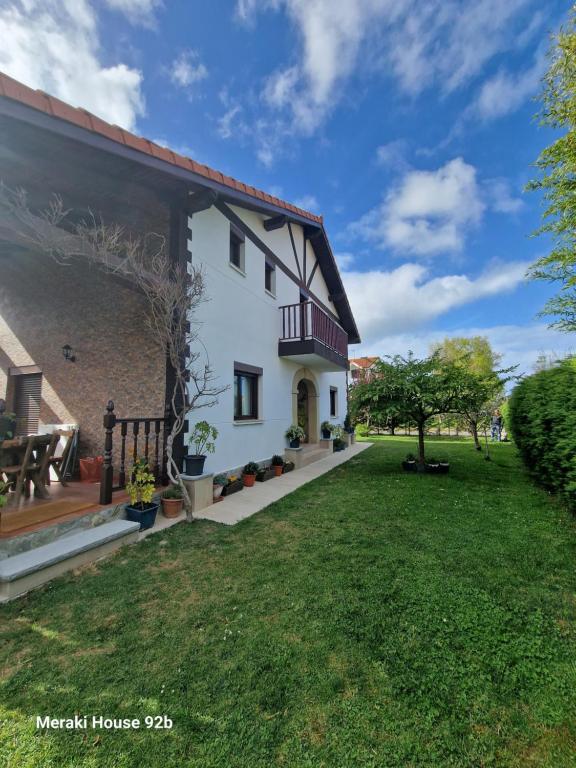 Biały dom z zielonym dziedzińcem w obiekcie Meraki House 92B w mieście Arnuero