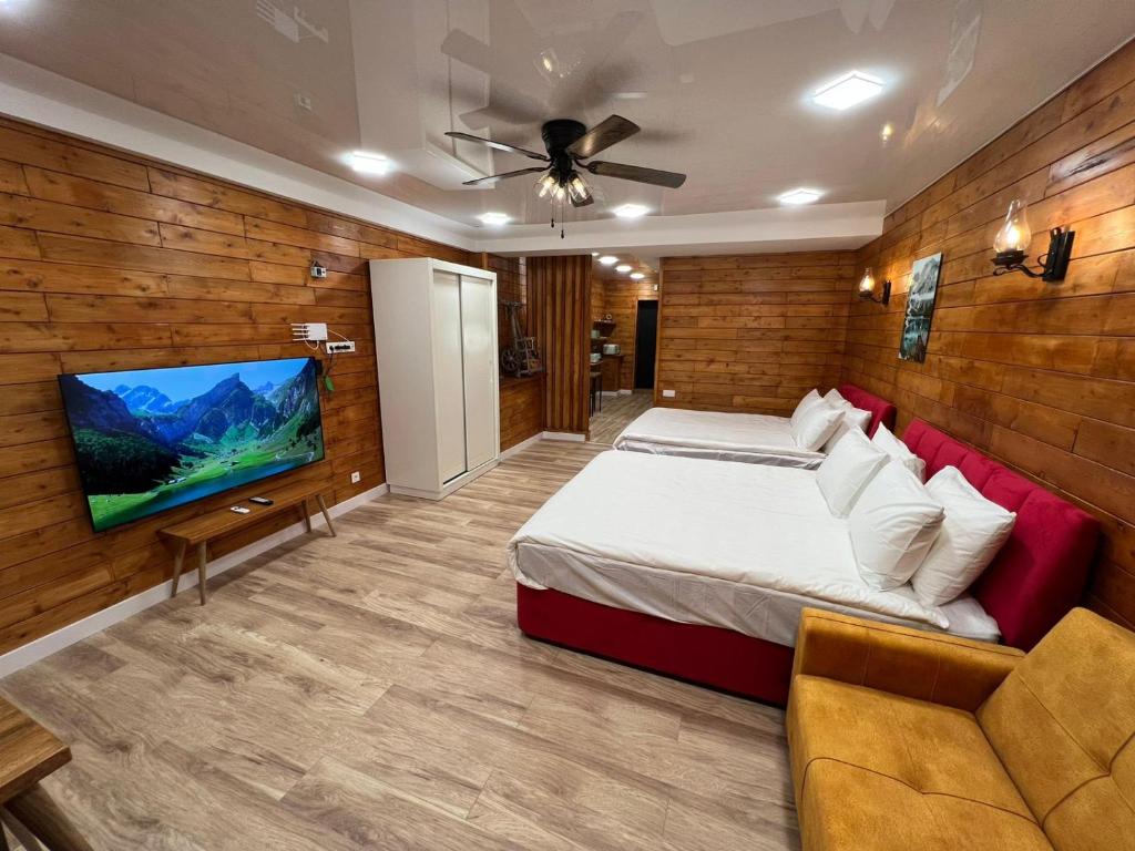 a bedroom with a bed and a flat screen tv at Politkovskaia Apartment Tbilisi in Agaraki