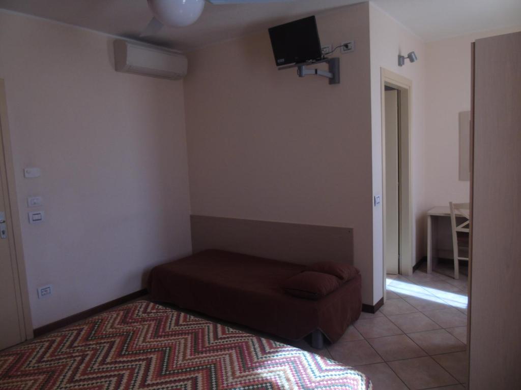 salon z kanapą i telewizorem na ścianie w obiekcie Albergo Grifone 1891 w mieście Peschiera del Garda