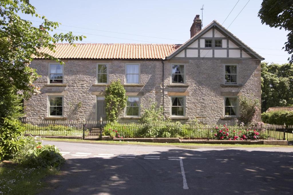 an old brick house with a gate and a street at The Cornmill in Kirkbymoorside