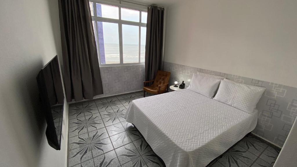 ein Schlafzimmer mit einem weißen Bett und einem Fenster in der Unterkunft Apartamento Frente à Praia Santos in Santos