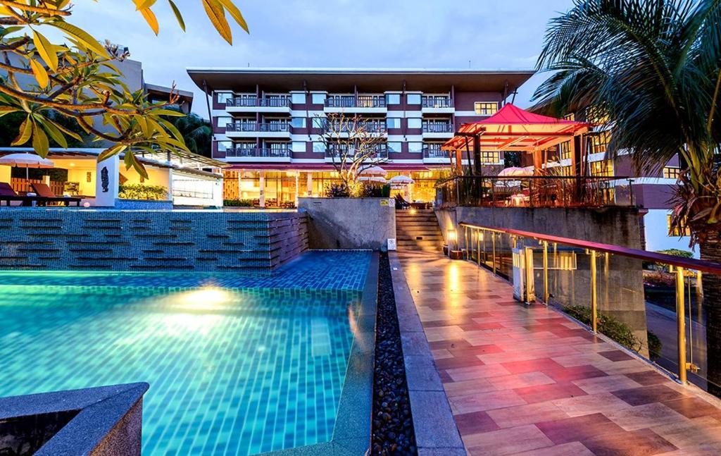 a swimming pool in front of a hotel at Peach Blossom Resort & Pool Villa - SHA Plus in Karon Beach