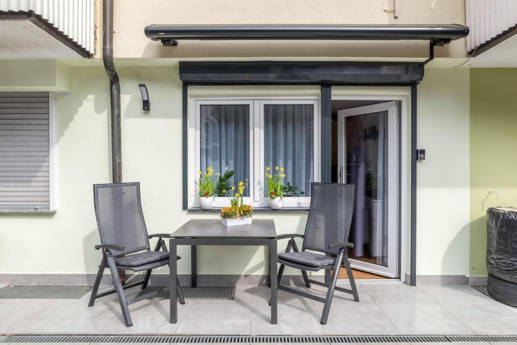 un patio con mesa y 4 sillas en Ferienwohnung Rennbächle, en Bad Wildbad