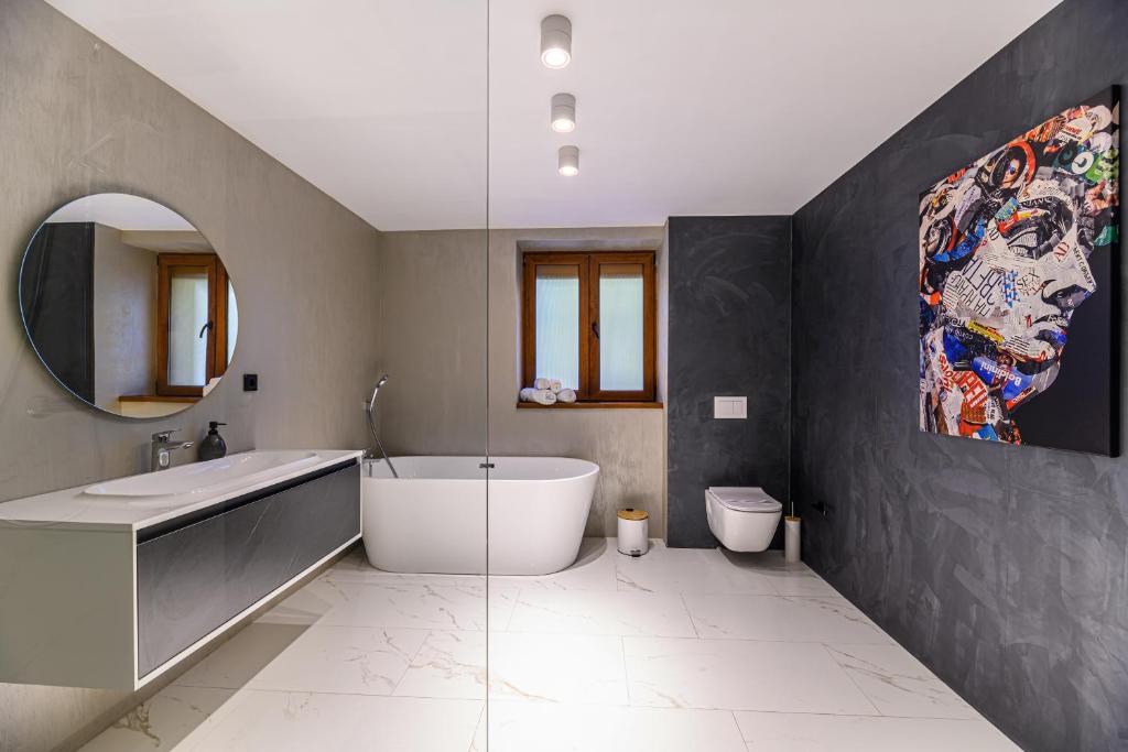 La salle de bains est pourvue d'une grande baignoire et d'un lavabo. dans l'établissement KOA - Memo Haus, à Braşov