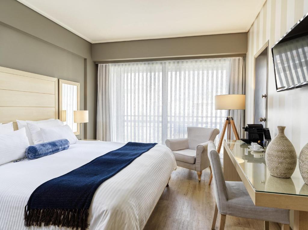 a bedroom with a bed and a desk and a chair at Sea View Hotel in Athens