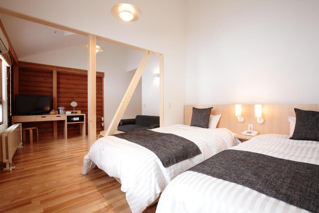 Un pat sau paturi într-o cameră la Log Hotel The Maple Lodge