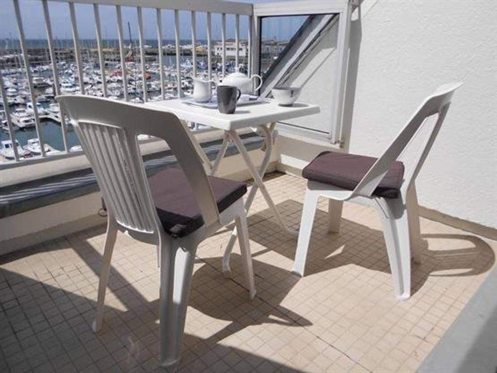 - un balcon avec une table et deux chaises dans l'établissement Appartement cosy à La Turballe - 2/4 pers, proche centre et plage, parking inclus - FR-1-392-95, à La Turballe