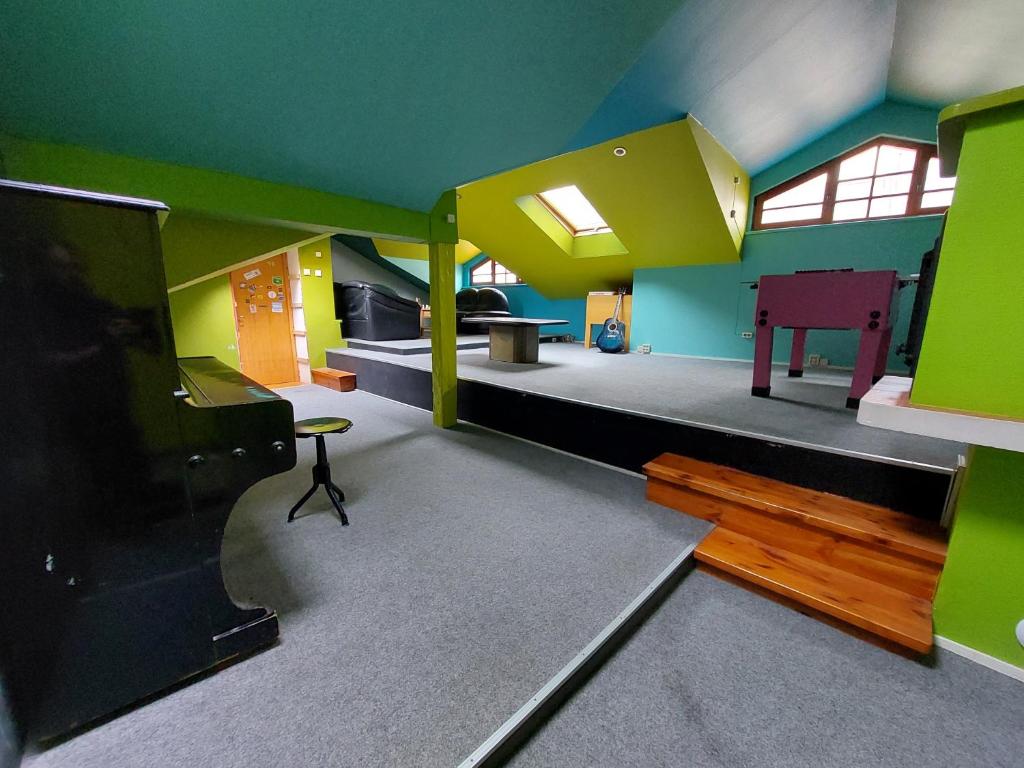 25 Hours Hostel في فيلنيوس: غرفة معيشة مع جدران خضراء وصفراء وتلفزيون