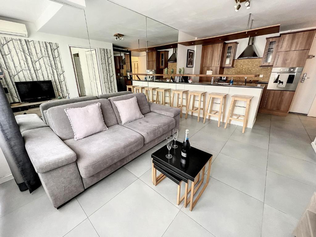 un salon avec un canapé et une cuisine dans l'établissement Superbe 2 pièces au calme absolu, à Cannes