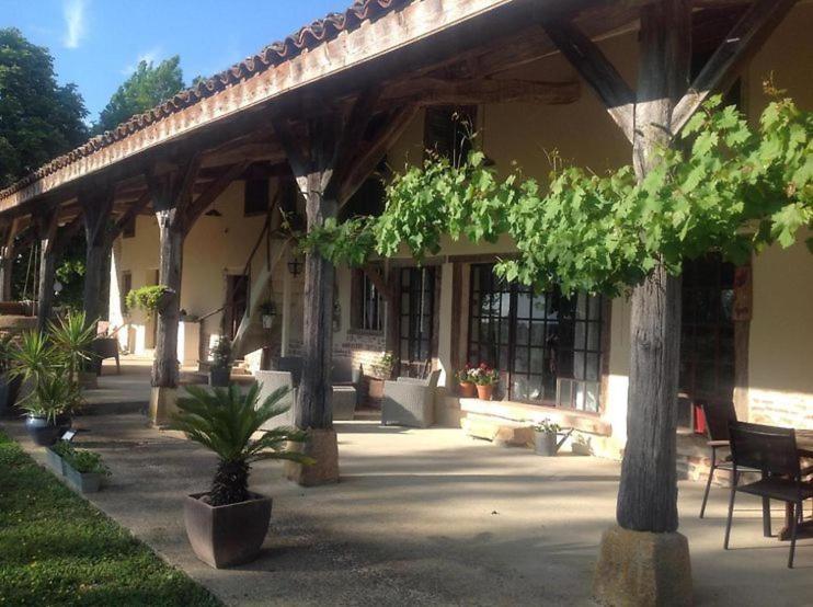 budynek z werandą z drzewami i krzesłami w obiekcie Domaine des Granges Neuves w mieście Confrançon