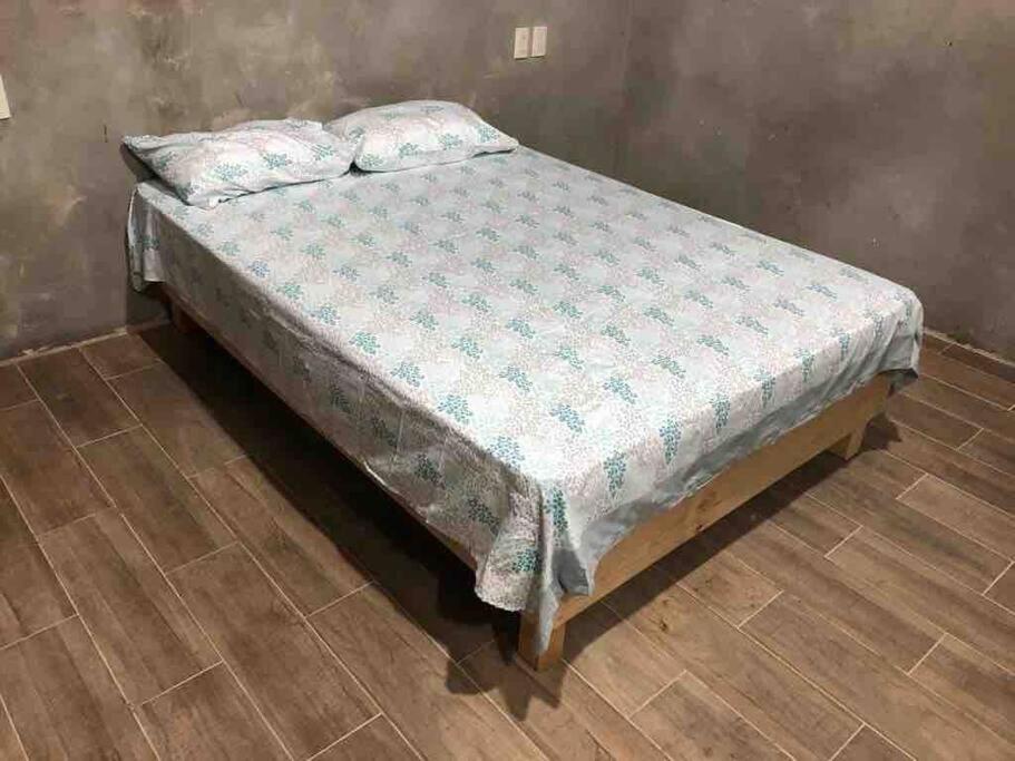 uma cama num quarto com piso em madeira em Lees' Beach House em Garita