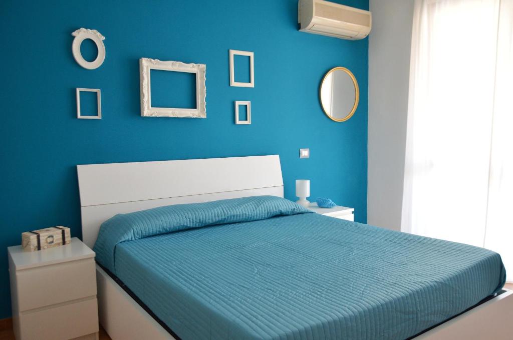 una camera blu con un letto con una parete blu di Il Sestante Santa Marinella a Santa Marinella