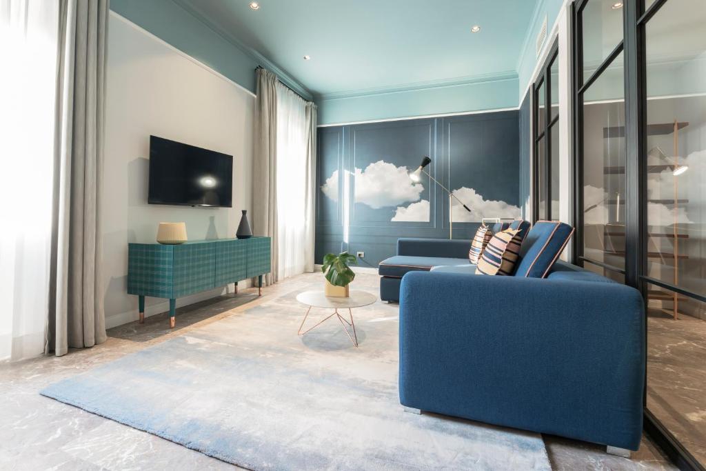 sala de estar con sofá azul y TV en Be Mate Trastevere II, en Roma