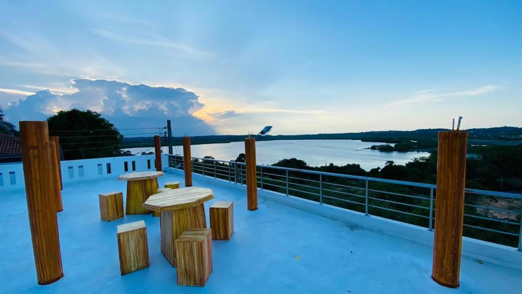 KPN Trinco Holiday Resort في ترينكومالي: منظر من سقف منزل مع كراسي خشبية