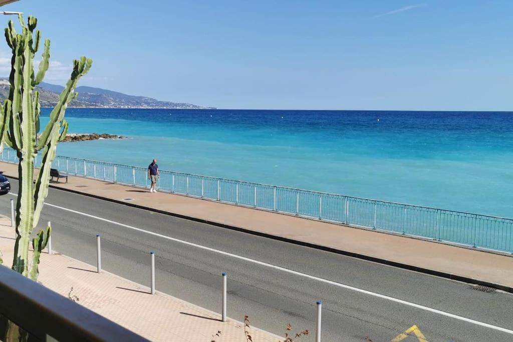 une personne marchant le long d'une route au bord de l'océan dans l'établissement Bellaviste trilocale vista mare, à Menton
