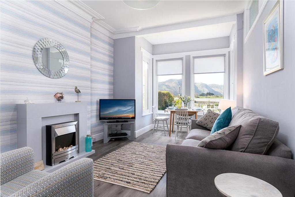 a living room with a couch and a fireplace at Sandbanks in Deganwy