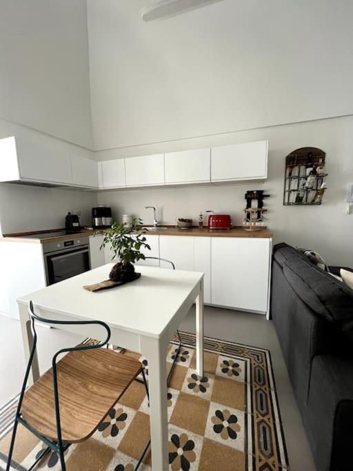 a kitchen with a white table and a couch at Cementina 56 in Noci