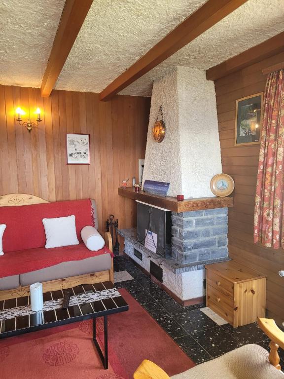 a living room with a red couch and a fireplace at La Crettaz app dans chalet - SUNNY apartment 6 p in Veysonnaz