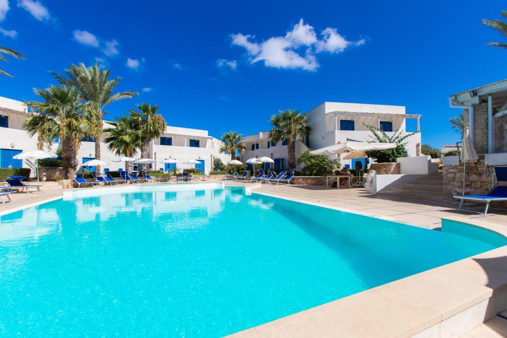 - une piscine en face d'une villa dans l'établissement Resort Cala La Luna, à Favignana