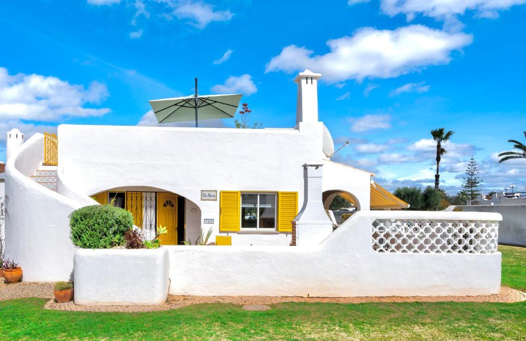 Biały dom z żółtymi drzwiami w obiekcie Villa PACA Algarve Vilamoura 8 personnes w mieście Quarteira