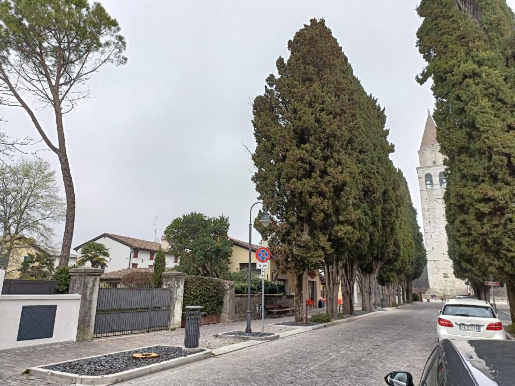 een straat met een auto geparkeerd op een weg met bomen bij Appartamento Popone 1 in Aquiléia