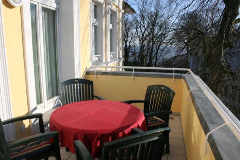 a red table and chairs on a balcony at Villa Granitz - Ferienwohnung 45453 (Gellen) in Göhren