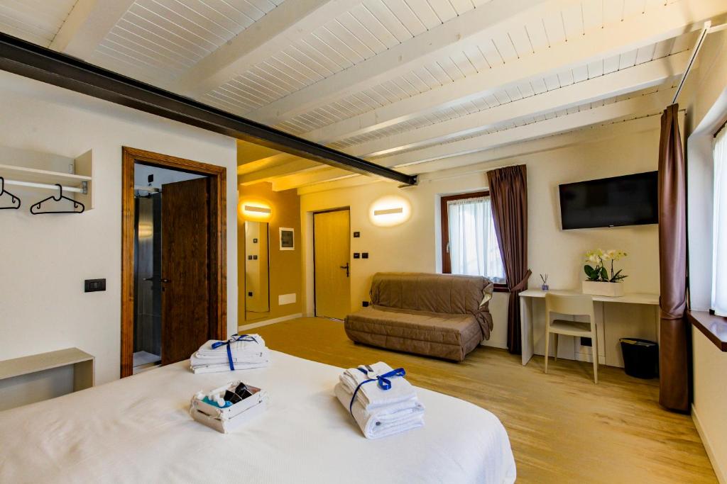 SòisにあるAppartamento immerso nella natura con parcheggio - Narcisoのベッドとソファのあるホテルの部屋