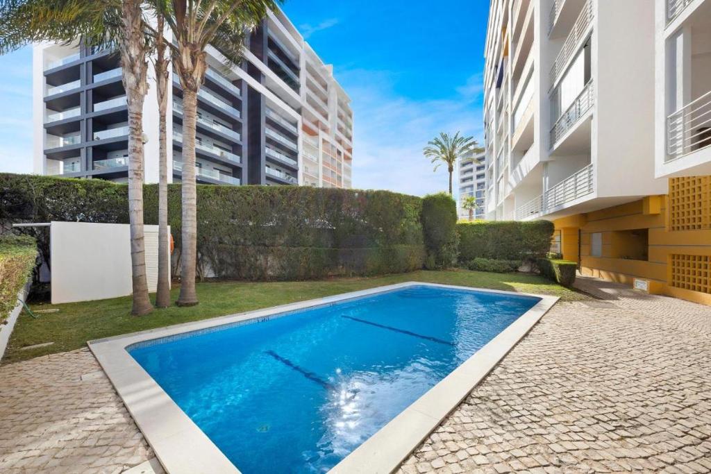uma piscina em frente a um edifício em Casa Sol, Fast WIFI, Airco, swimming pool near Praia Da Rocha em Portimão