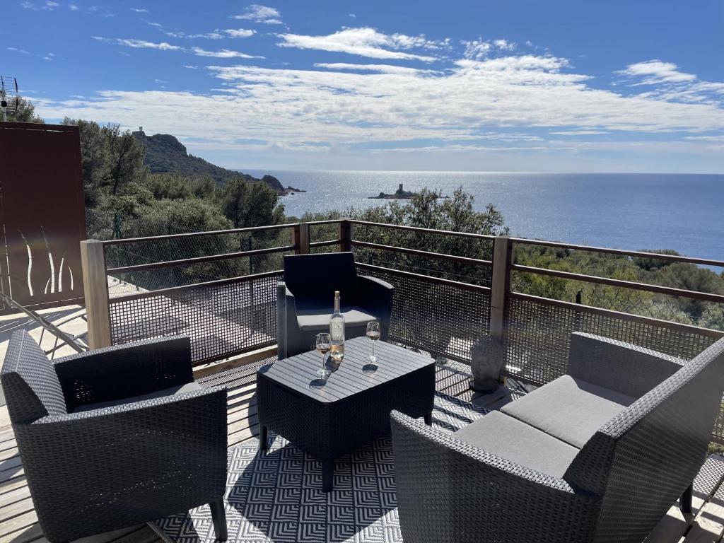 balcón con mesa, sillas y vistas al océano en Blue Horizon en Saint-Raphaël