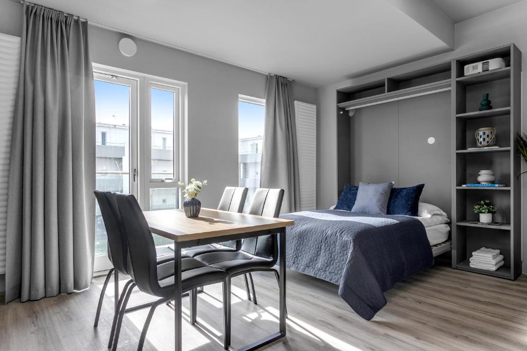 een slaapkamer met een bed en een tafel en stoelen bij B18 Apartments in Reykjavík